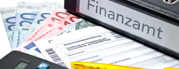 Ordner "Finanzamt" mit Steuerformularen, Euroscheinen, Taschenrechner und Kugelschreiber Ordner "Finanzamt" mit Steuerformularen, Euroscheinen, Taschenrechner und Kugelschreiber
